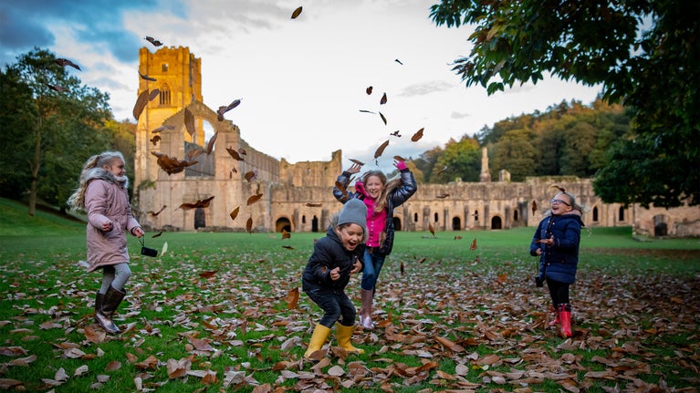 Autumn fun with leaves on the west green of Fountains Abbey 4 kids